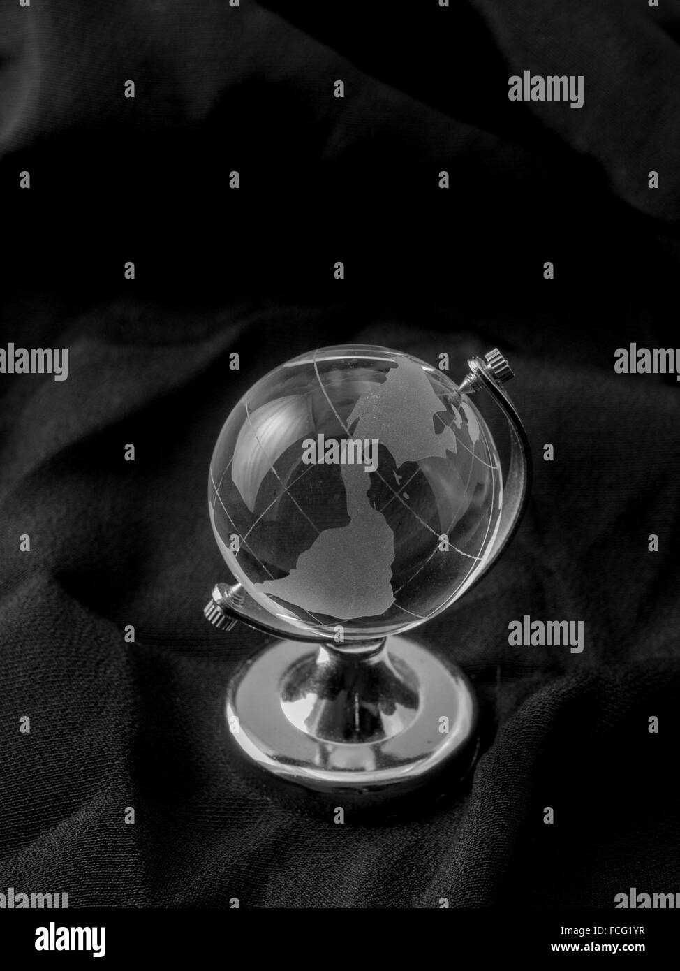 Globo di vetro sul cavalletto d'argento su panno nero. Foto Stock