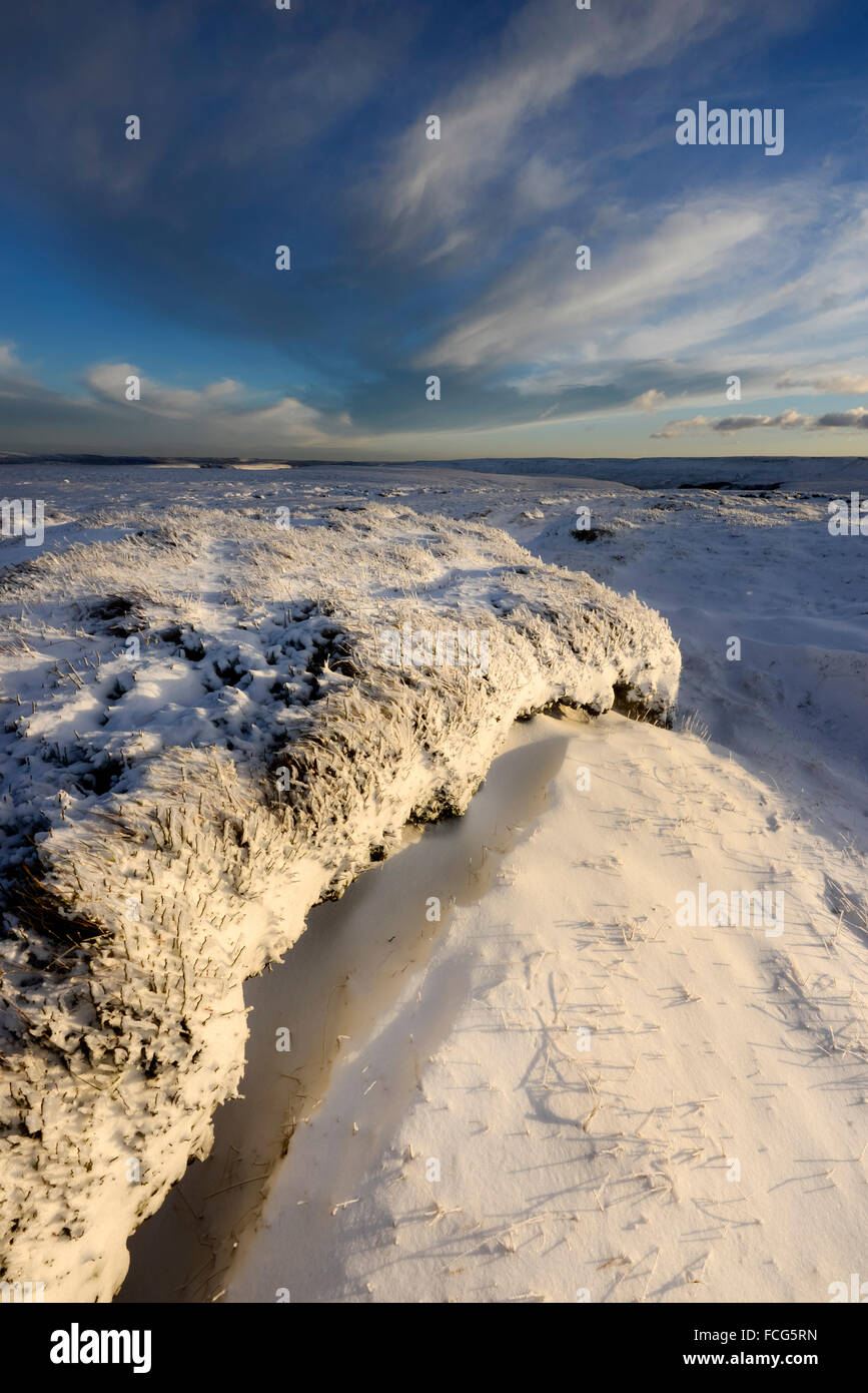 Snowy brughiera a fianco del The Pennine Way sopra Glossop nel Derbyshire su una splendida serata invernale al tramonto. Foto Stock