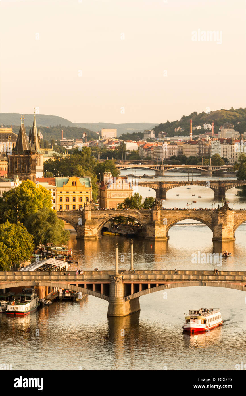 I vecchi ponti in pietra che attraversa il fiume Moldava con un tour in barca visibile nella città di Praga, Repubblica Ceca. Foto Stock