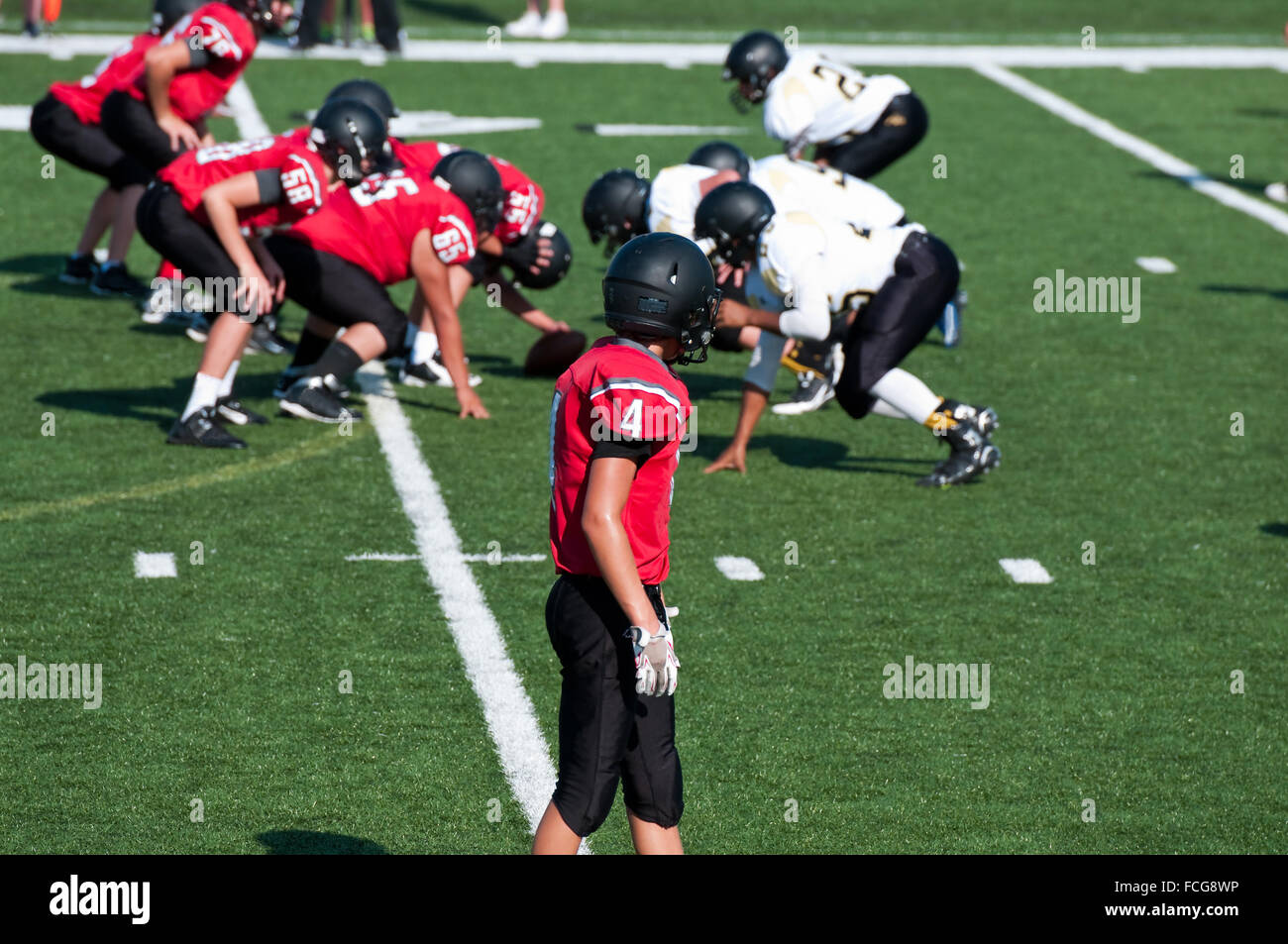 Alta Scuola di football americano in attesa del ricevitore per PLAY per avviare durante il gioco. Foto Stock