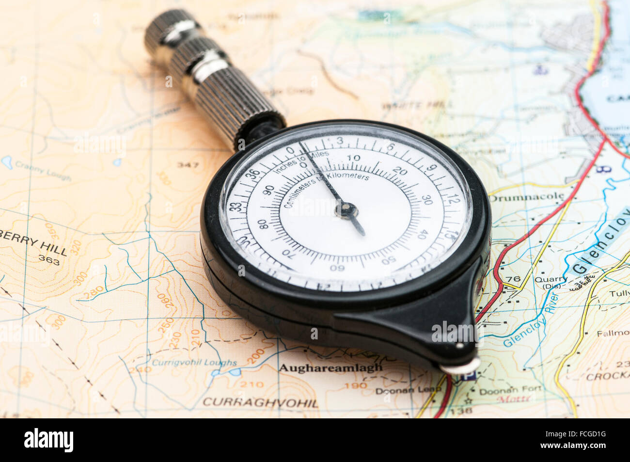 Mappa ruota su una mappa, utilizzato per misurare le distanze con scale differenti. Foto Stock