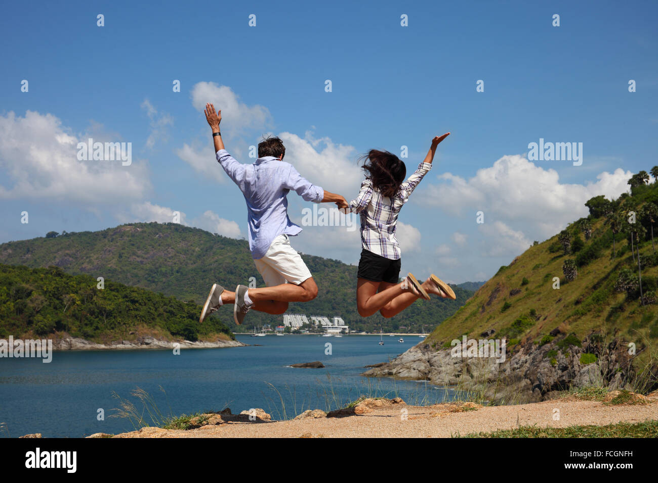 Giovane coppia felice salto e godono di una bella vista sul mare in vacanza Foto Stock