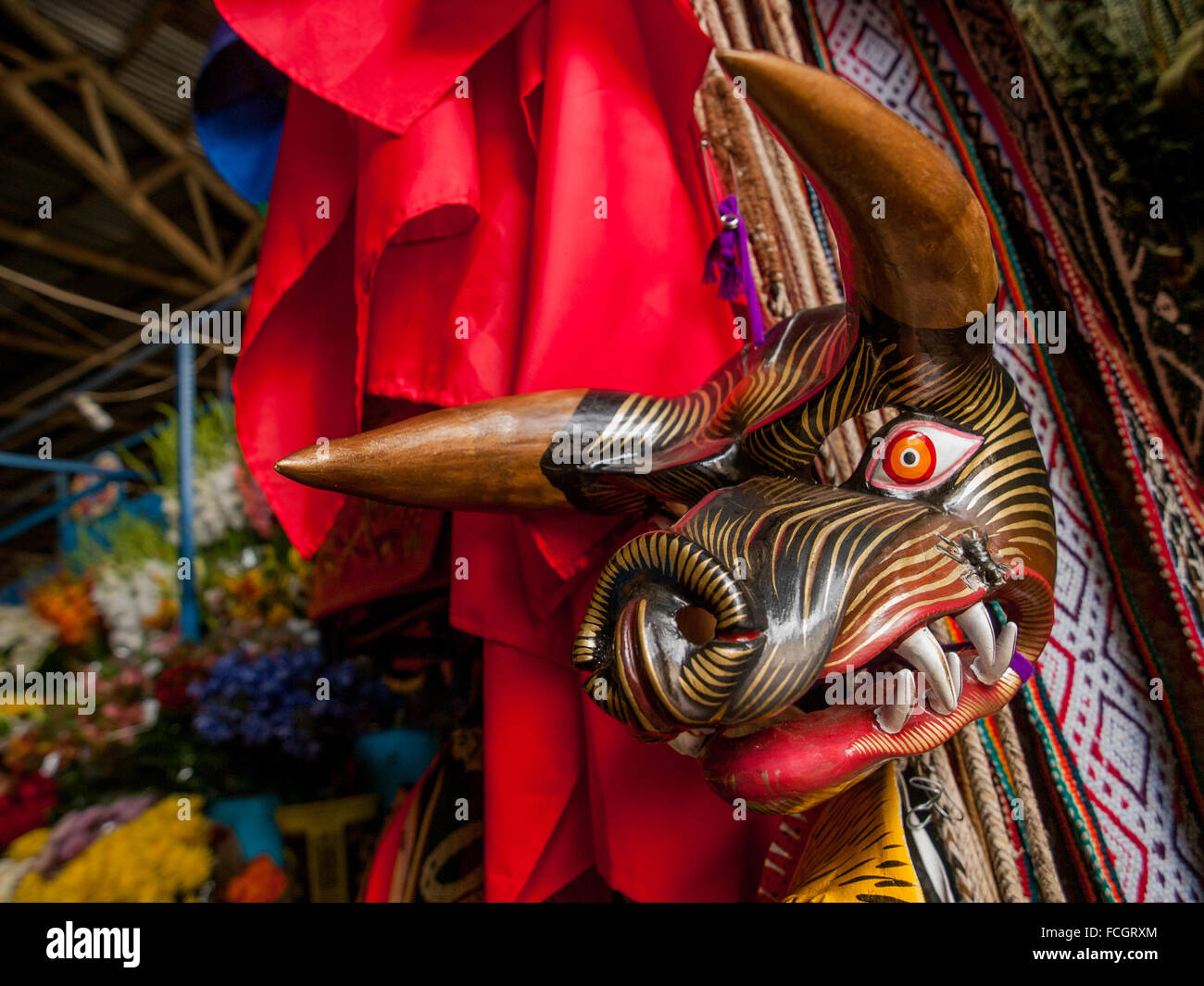 Nero e rosso e oro maschera di cinghiale appesa sul muro al mercato di Cusco in Perù, Sud America. Foto Stock