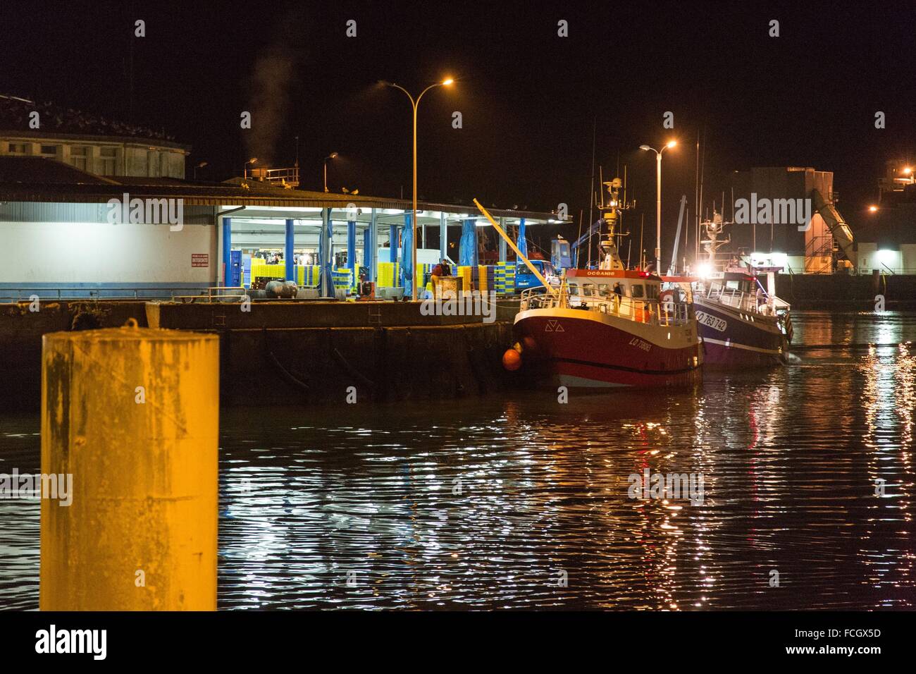Barca da pesca lo scarico di sue catture presso il mercato del pesce di notte sul Porto di Lorient (56), Francia Foto Stock