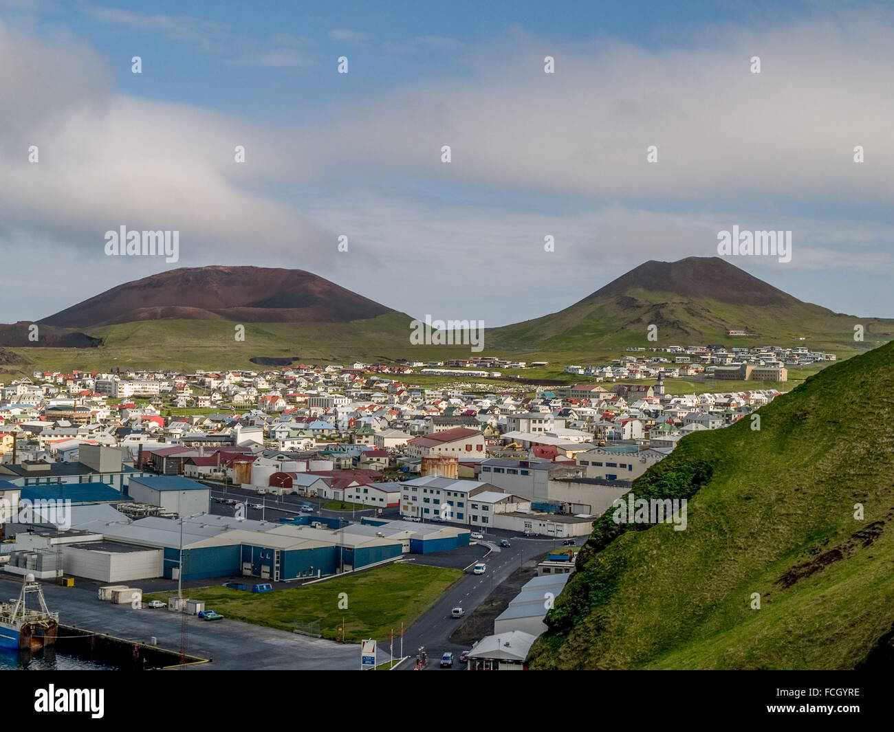 E Eldfell Helgafell vulcani nella parte anteriore del paesaggio urbano in Heimaey, Vestmannaeyjar, Islanda. Foto Stock