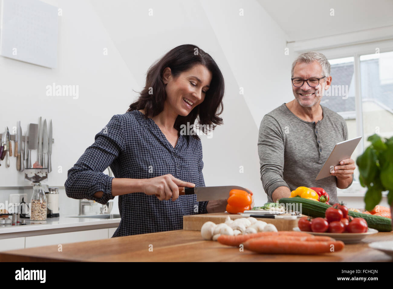 Coppia matura tavoletta digitale per la cottura in cucina Foto Stock