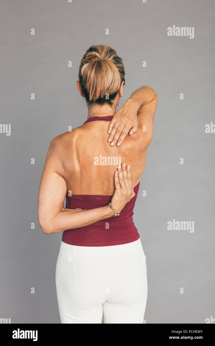 Donna matura le spalle e le braccia esercizio di stretching Foto Stock