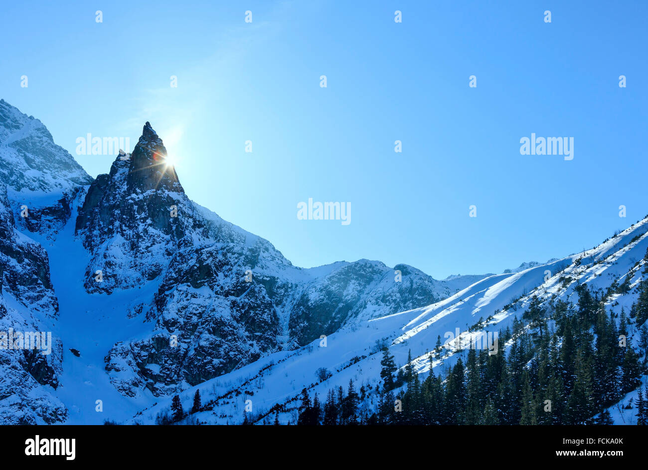 Inverno Rocky Mountain View e picchi di sole fuori da dietro le rocce. Foto Stock