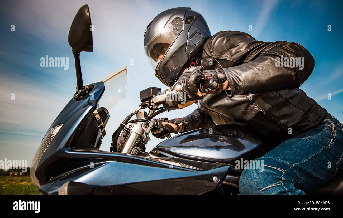 Biker in casco e giacca di pelle racing su strada Foto Stock Biker in casco e giacca di pelle racing su strada Foto Stock