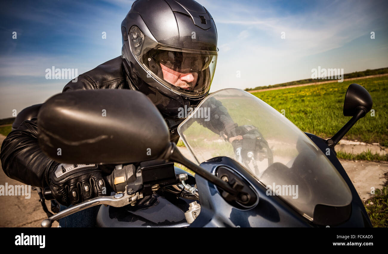 Biker in casco e giacca di pelle racing su strada Foto Stock Biker in casco e giacca di pelle racing su strada Foto Stock