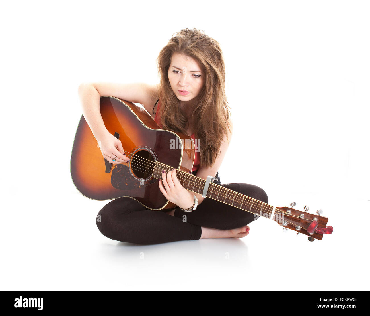 Ragazza giovane svolge la sua chitarra su sfondo bianco Foto Stock