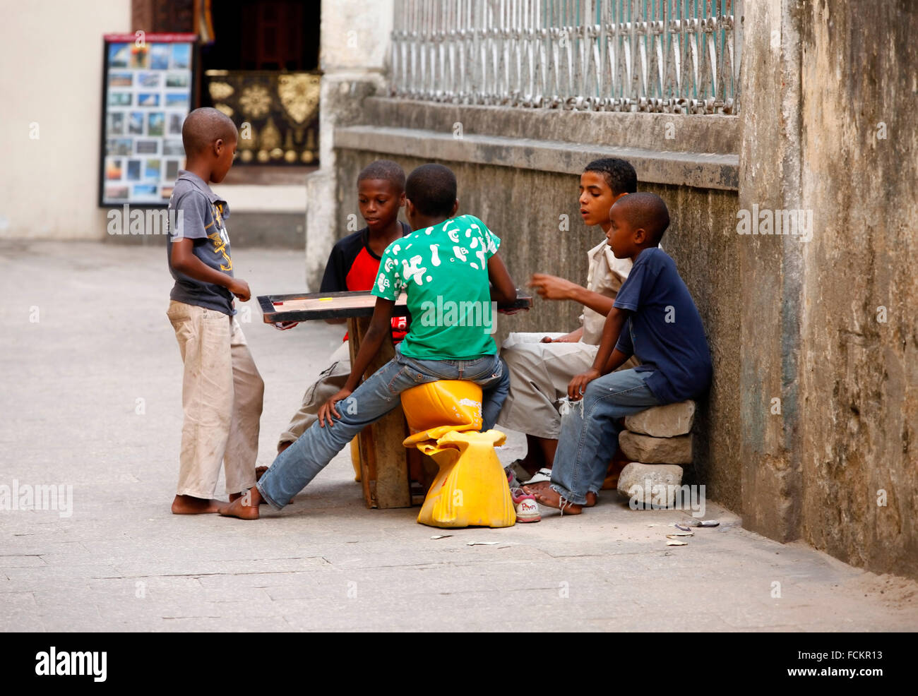 Zanzibar, Tanzania - Gennaio 10, 2016: Africa Orientale, sconosciuto dark scuoiati bambini, circa 8 anni, giocare all'aperto, in pietra Foto Stock