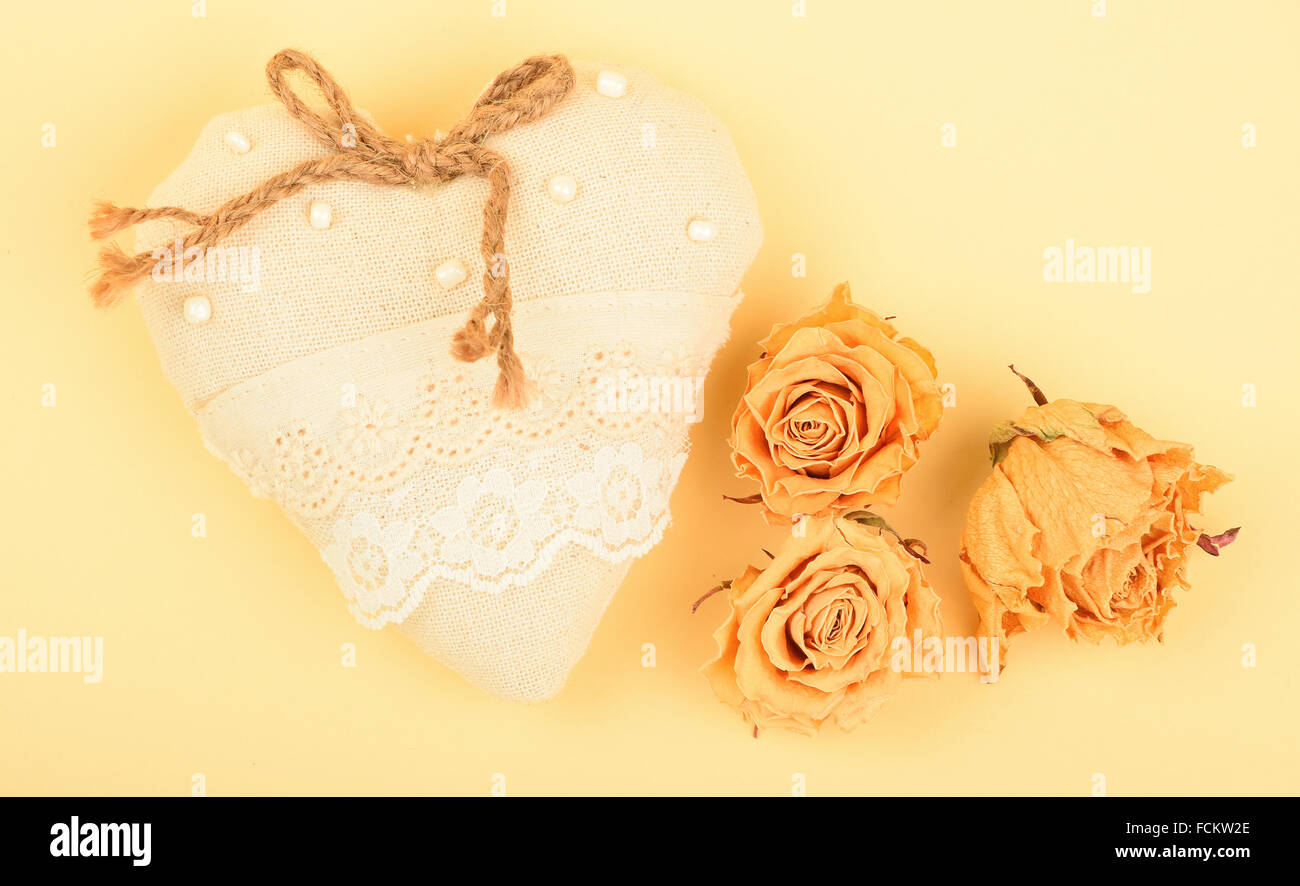 Modello di san valentino, fatti a mano giocattolo beige tessile cuore in pizzo con tela di iuta, prua perline essiccate, rose e spazio copia sul design pape Foto Stock