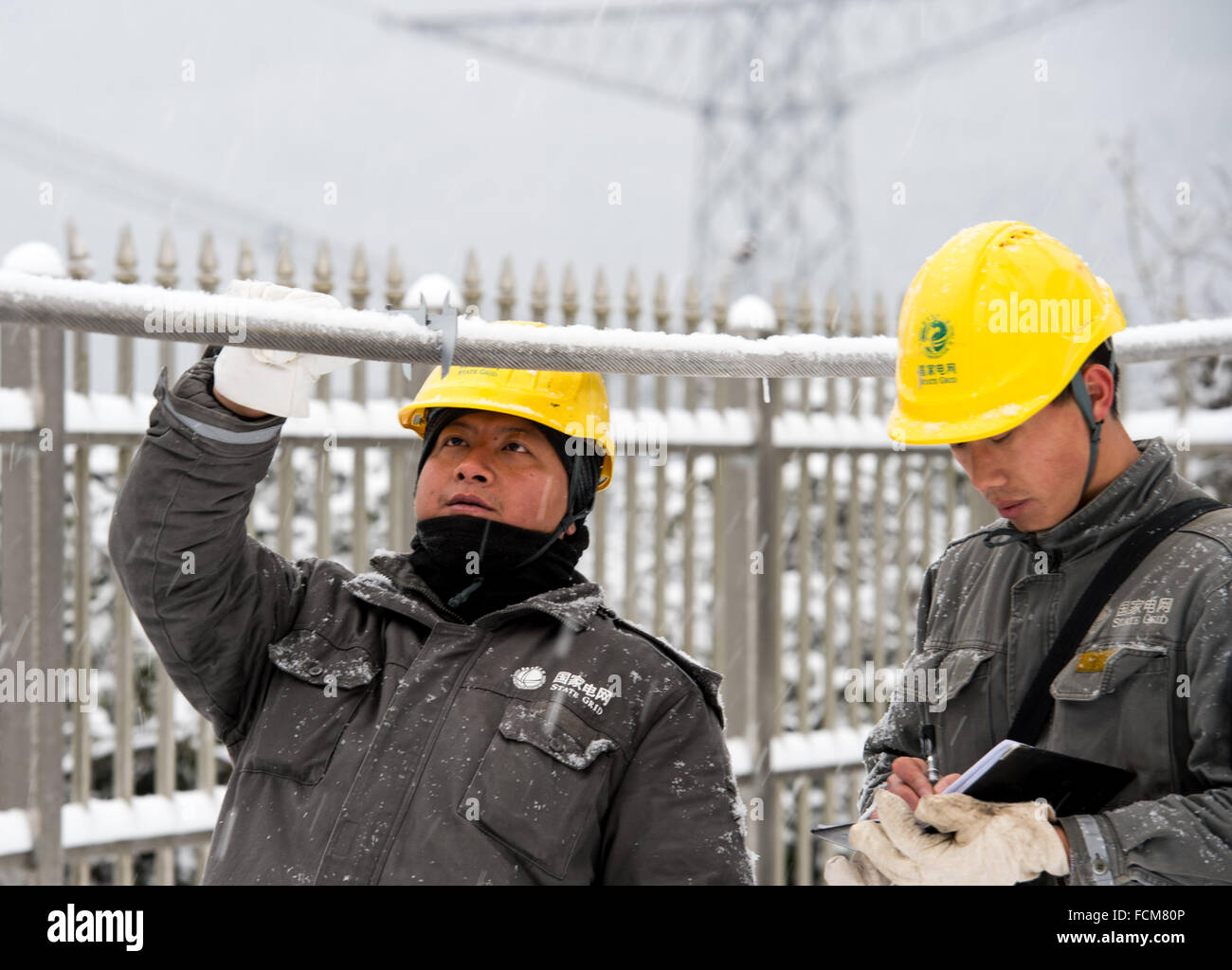 Pechino, Cina. 23 gen 2016. Due elettricisti pattuglia a monte Chepan nella contea di Wulong in Chongqing Cina centrale, il 23 gennaio, 2016. Chongqing power grid company avvia immediatamente una risposta di emergenza piano per fissare l'alimentazione dopo l'ondata di freddo ha colpito qui sabato. © Liu Chan/Xinhua/Alamy Live News Foto Stock
