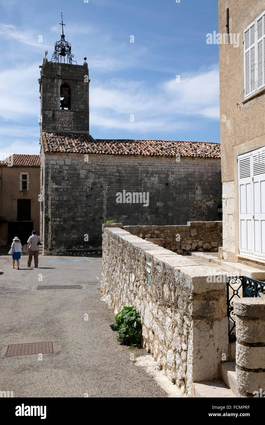 Due turisti di passeggiare nei pressi della chiesa nel villaggio provenzale di Mons, dipartimento del Var, Francia meridionale. Foto Stock