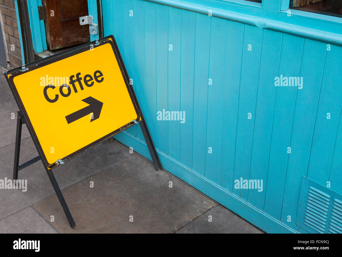 Un cartello indicante la direzione per le persone che hanno bisogno di un caffè. Foto Stock