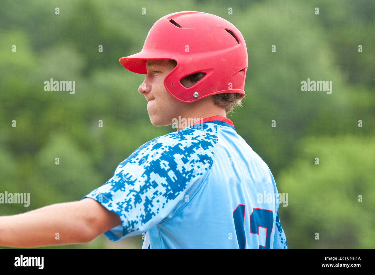 Close-up di alta scuola baseball teen in rosso casco in attesa di bat Foto Stock