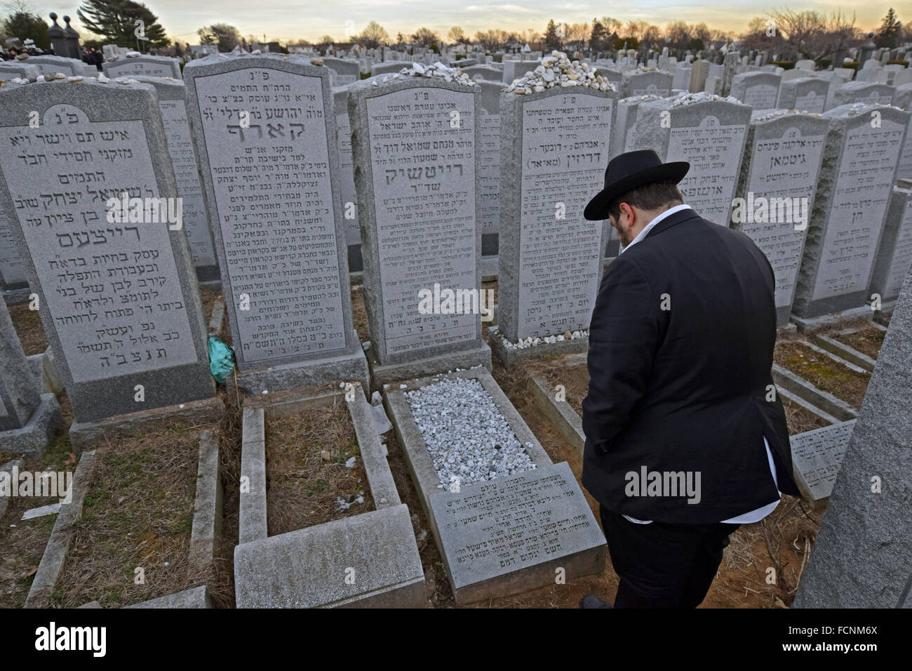 Una religiosa ebraica boy paga rispetta ad un parente deceduto a Montefiore cimitero di Cambria Heights, Queens, a New York Foto Stock