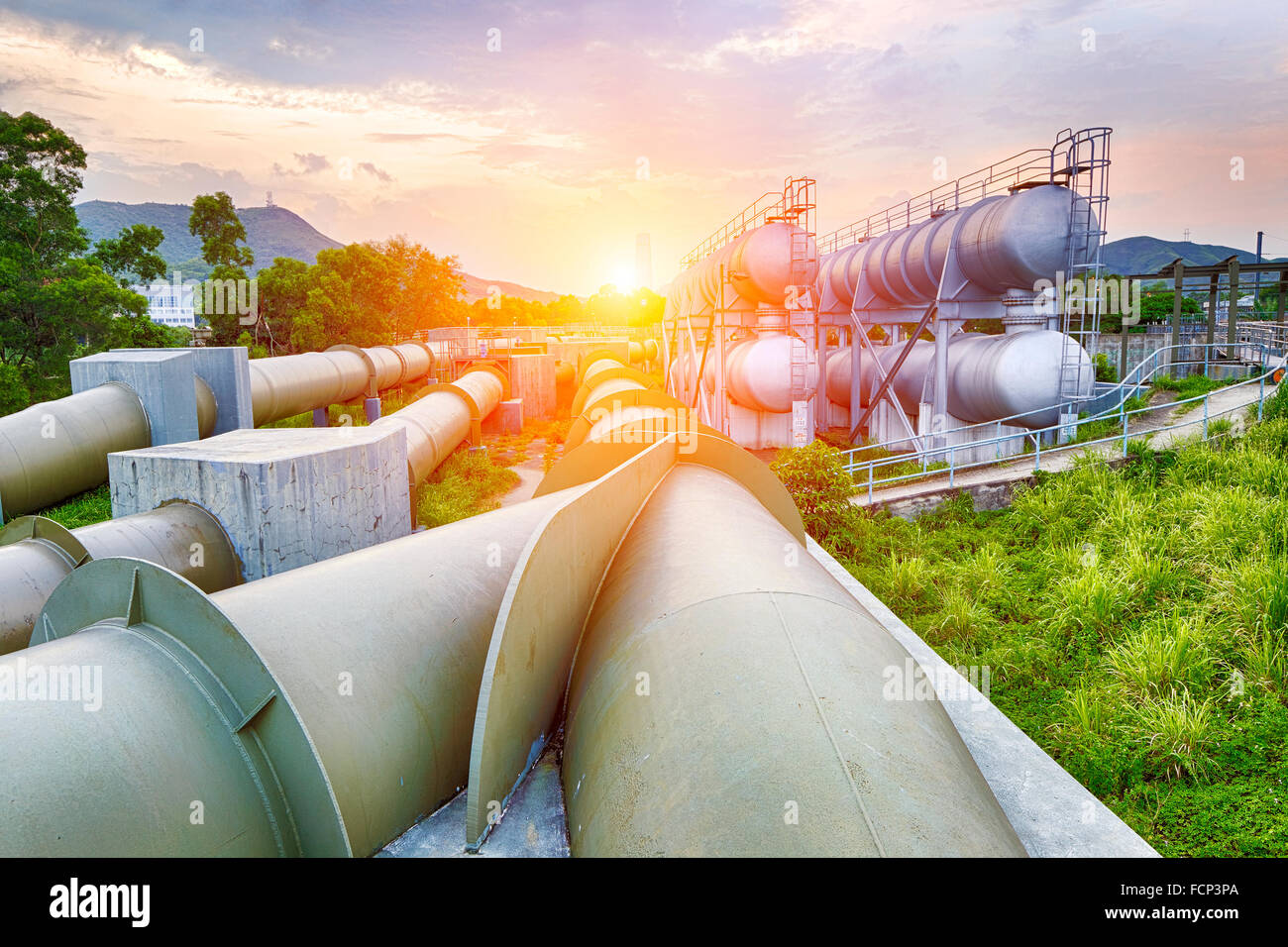 Industria petrolifera e del gas di raffineria in fabbrica al tramonto, impianto petrolchimico Foto Stock