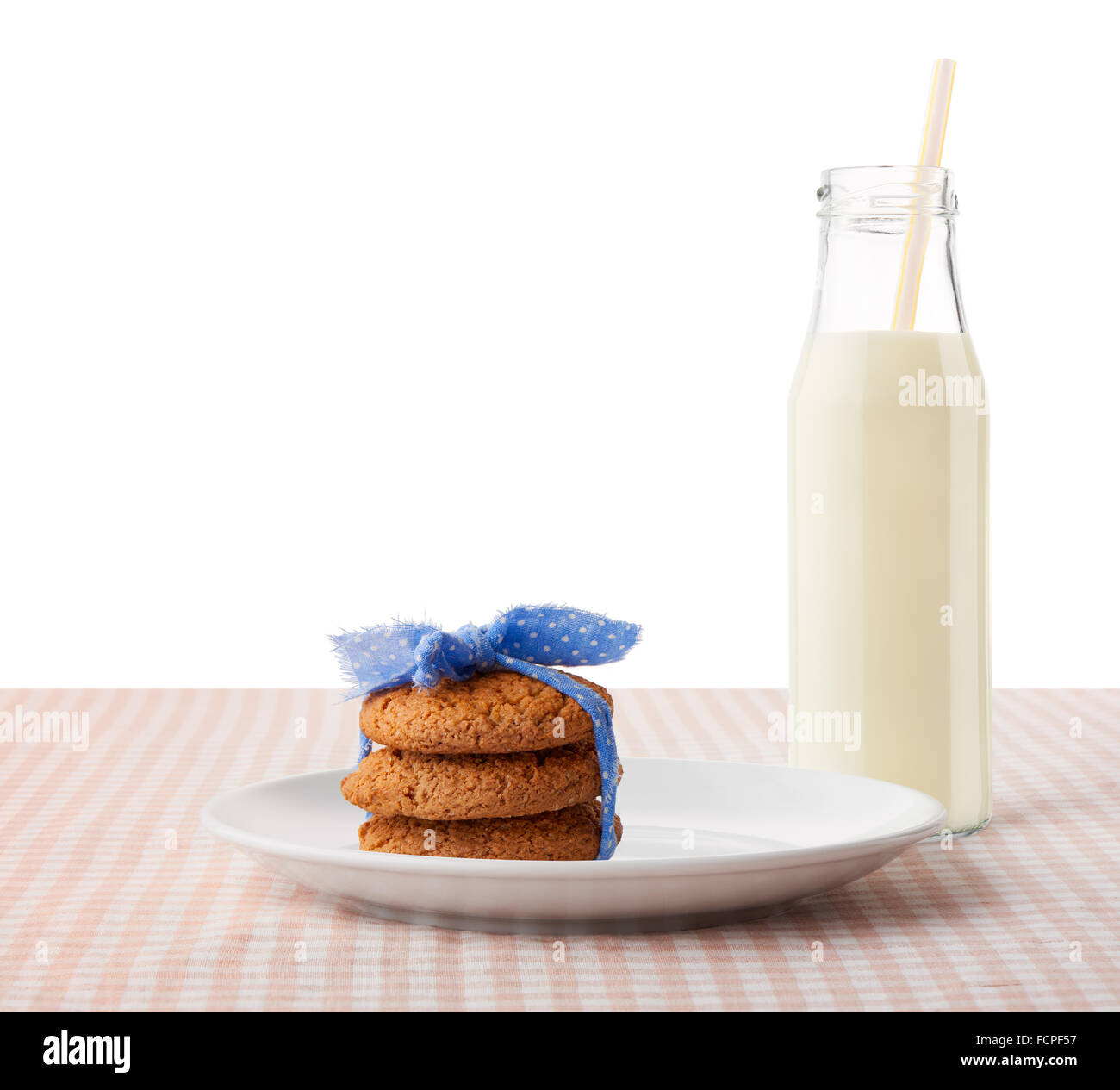Pila di tre in casa i fiocchi d'avena cookie legate con nastro blu su bianco piastra ceramica e bottiglia di latte Foto Stock