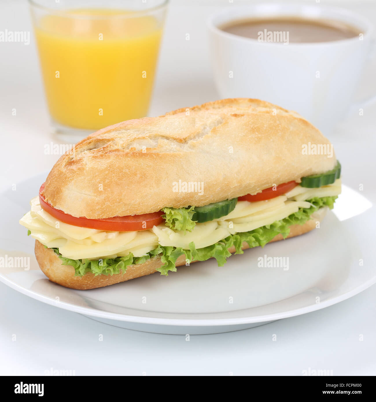 Mangiare sano sub deli sandwich baguette per colazione con formaggio, pomodori, lattuga e succo di arancia Foto Stock