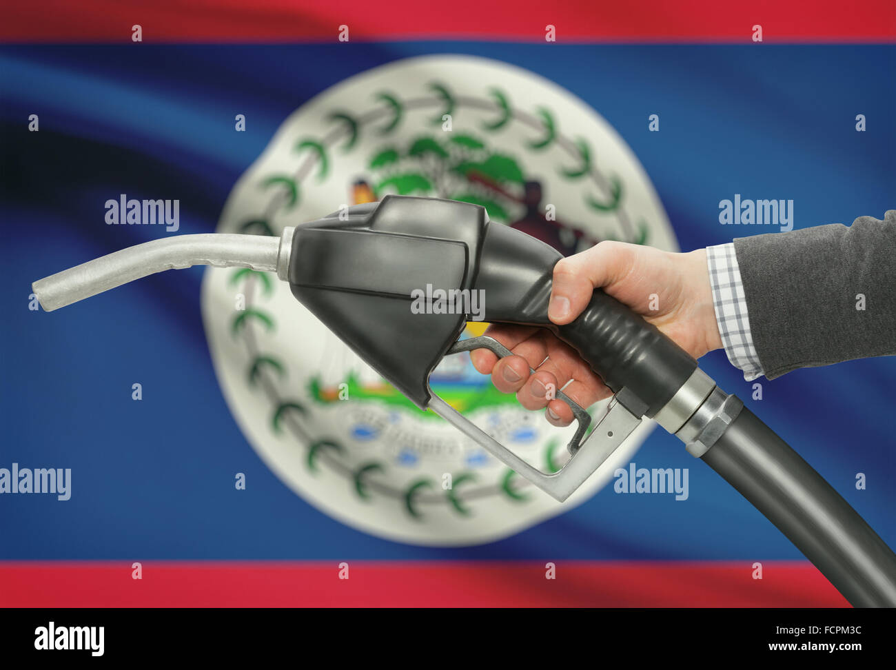 Pompa carburante ugello in mano con bandiera su sfondo - Belize Foto Stock