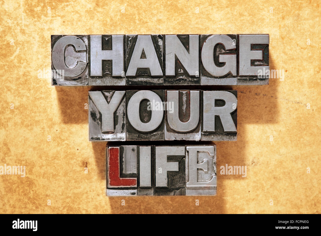 Cambia la tua vita fatta da metallico tipo di stampa in rilievo su grunge sfondo di cartone Foto Stock