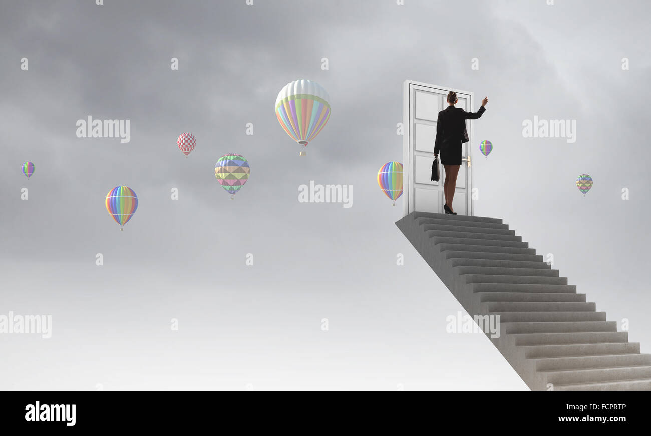 Imprenditrice a piedi fino alla scalinata porta in cielo Foto Stock
