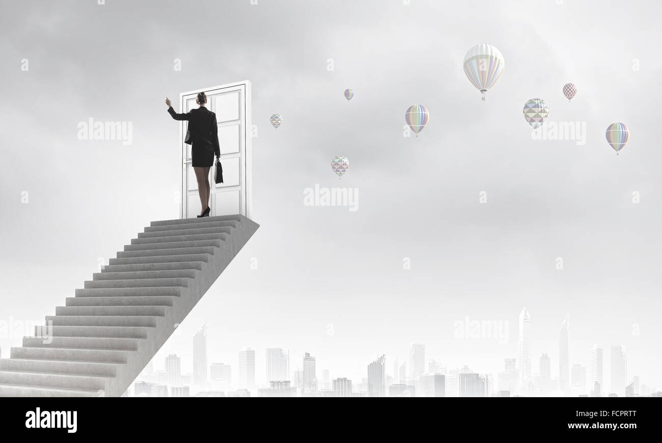Imprenditrice a piedi fino alla scalinata porta in cielo Foto Stock