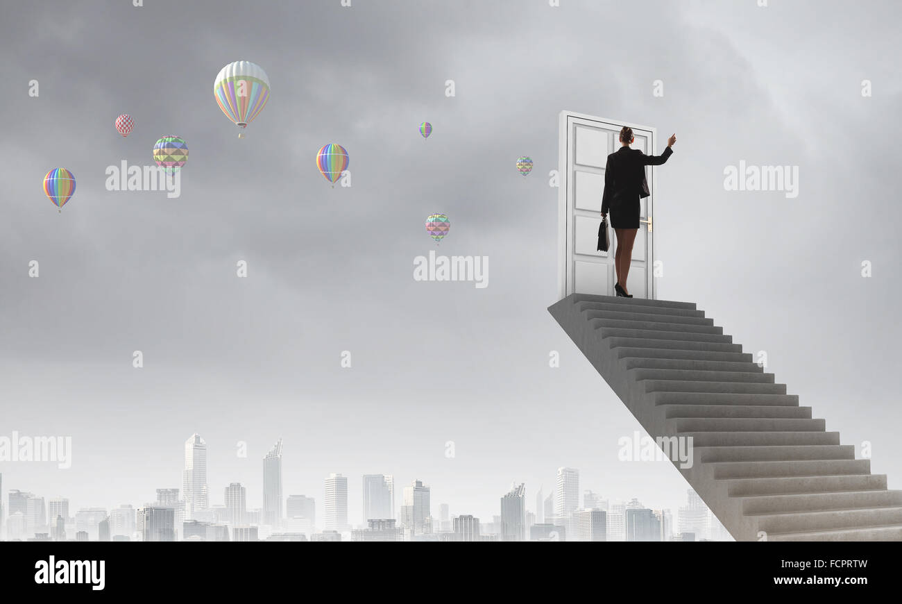 Imprenditrice a piedi fino alla scalinata porta in cielo Foto Stock