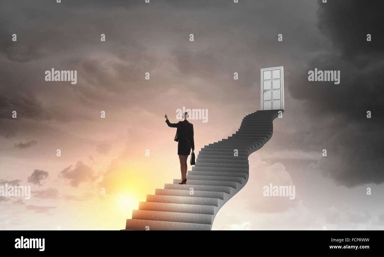 Imprenditrice a piedi fino alla scalinata porta in cielo Foto Stock