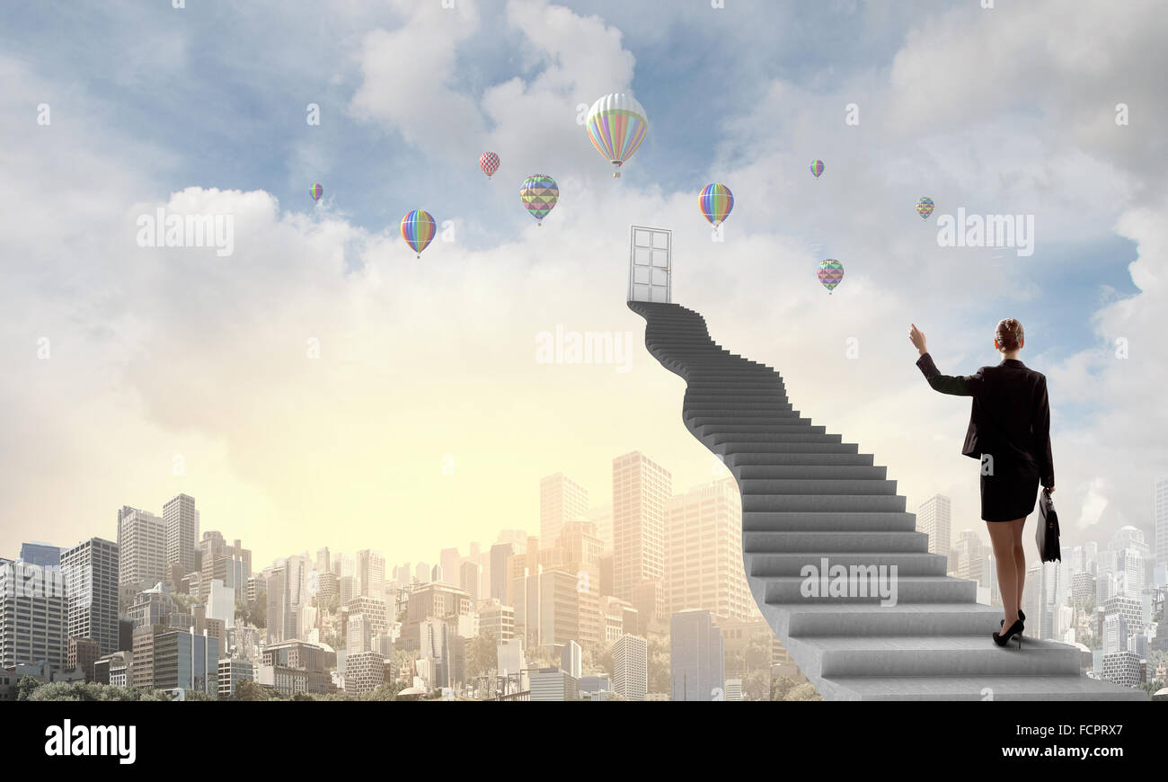 Imprenditrice a piedi fino alla scalinata porta in cielo Foto Stock