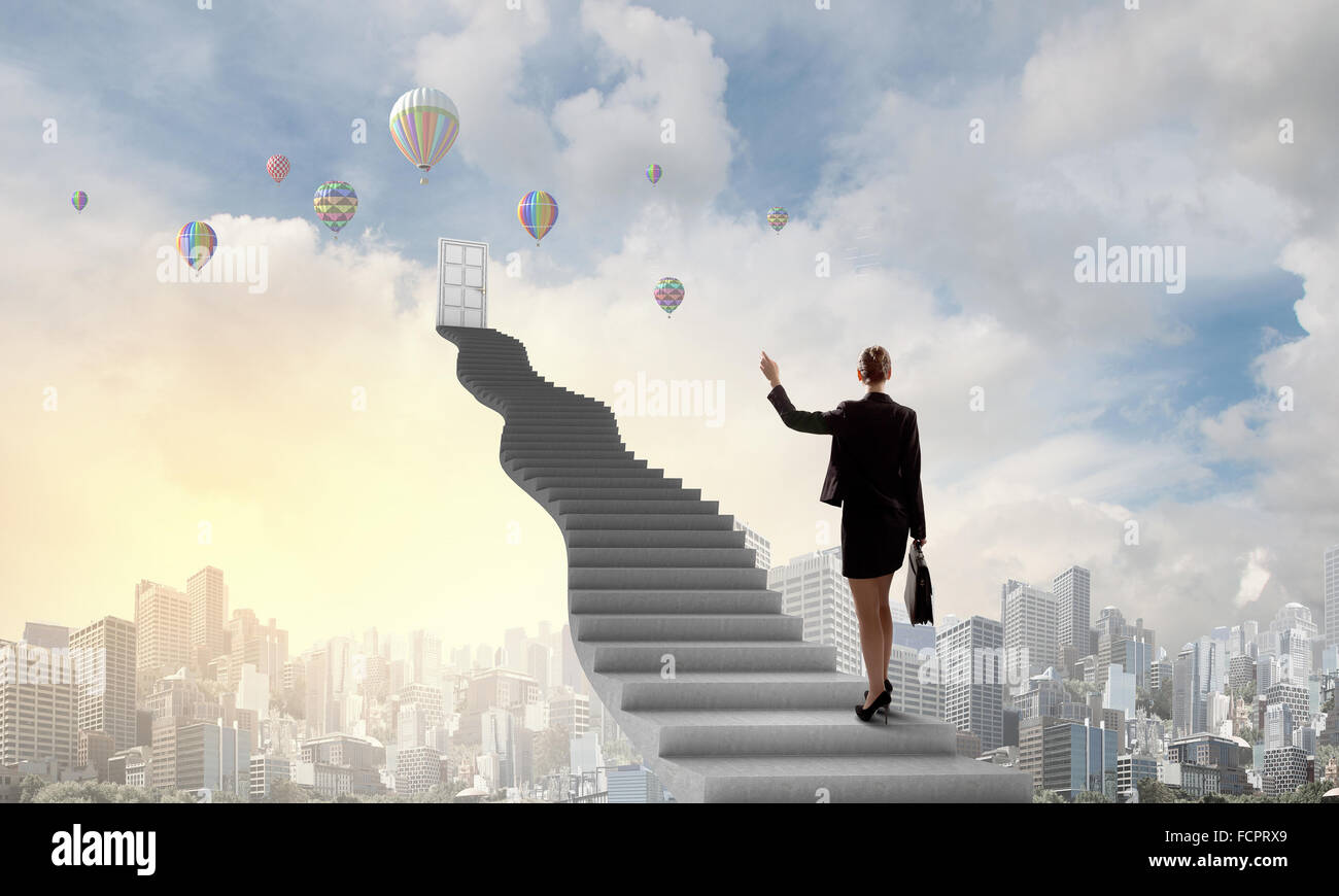 Imprenditrice a piedi fino alla scalinata porta in cielo Foto Stock