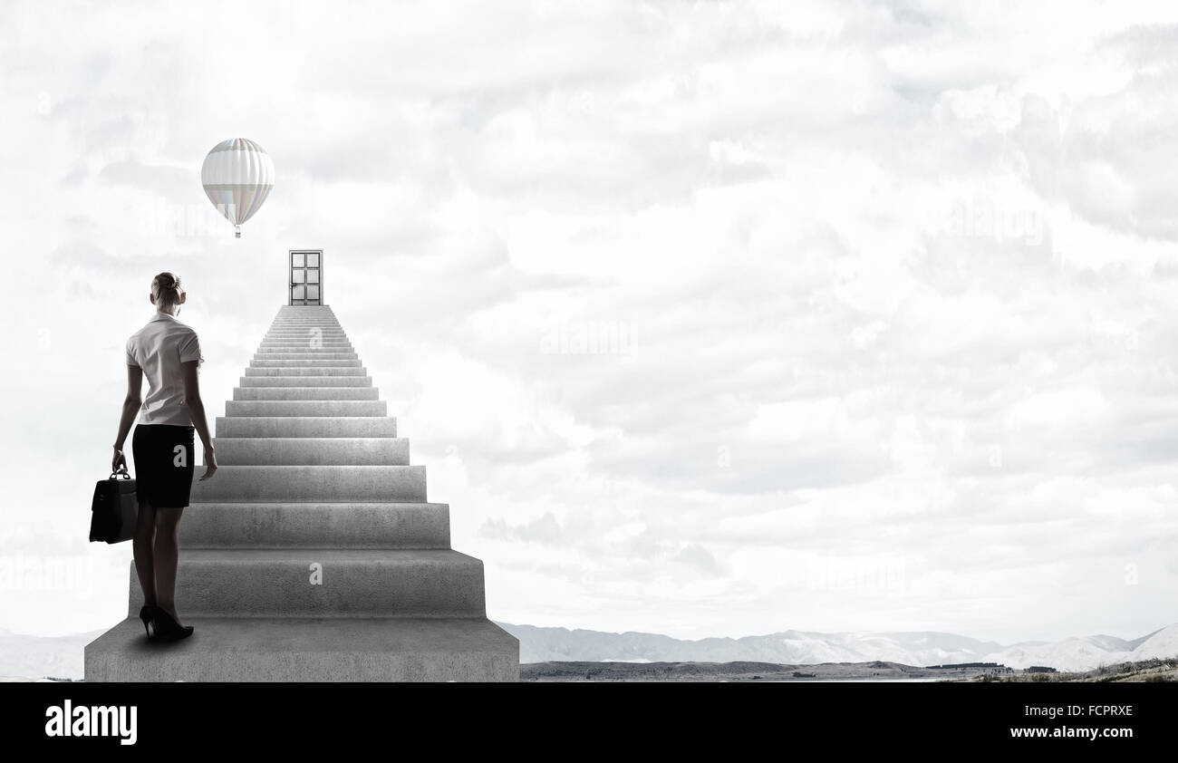 Imprenditrice a piedi fino alla scalinata porta in cielo Foto Stock