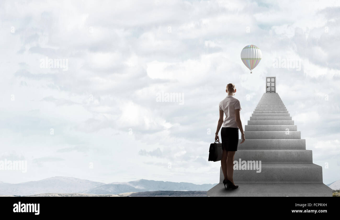 Imprenditrice a piedi fino alla scalinata porta in cielo Foto Stock