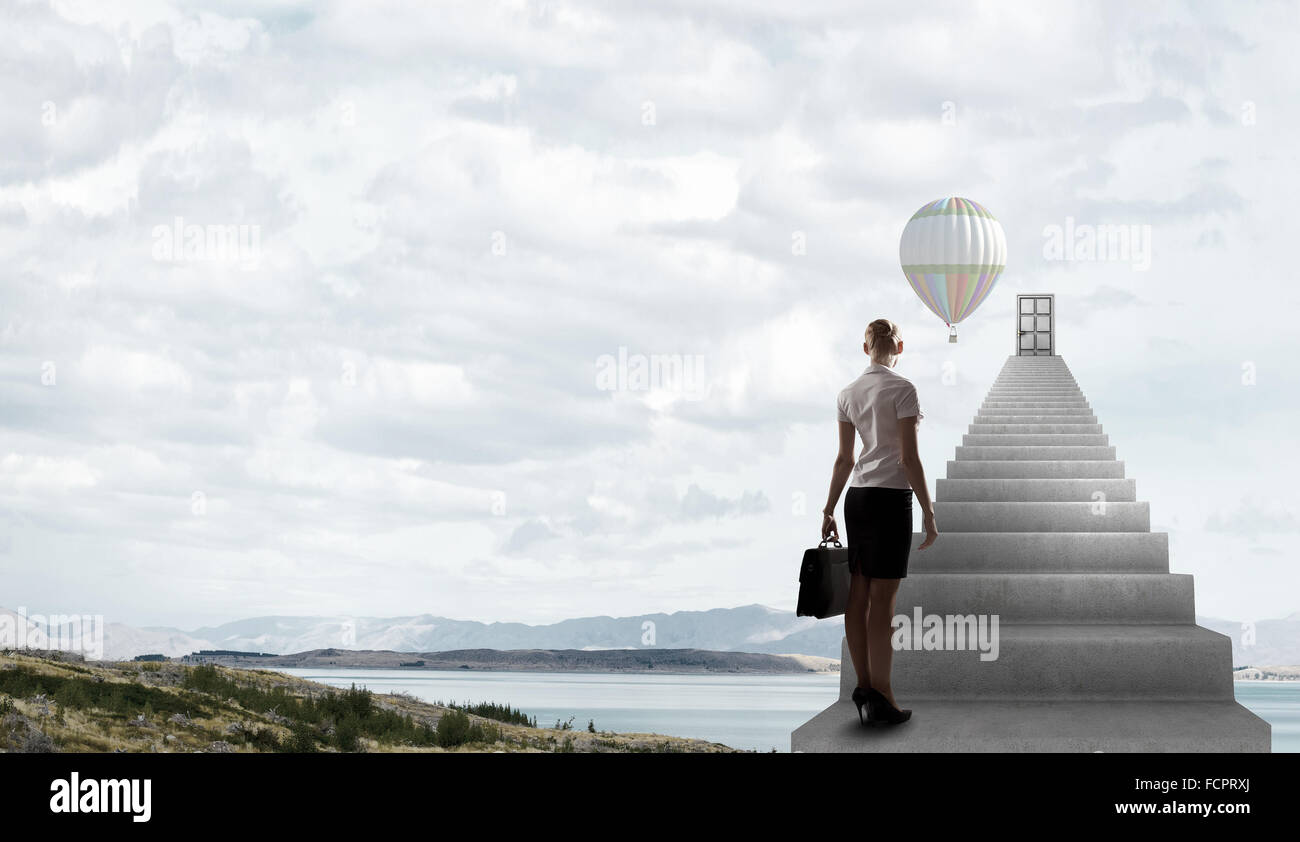 Imprenditrice a piedi fino alla scalinata porta in cielo Foto Stock