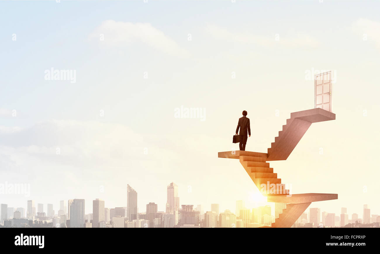 Imprenditore a piedi fino alla scalinata porta in cielo Foto Stock