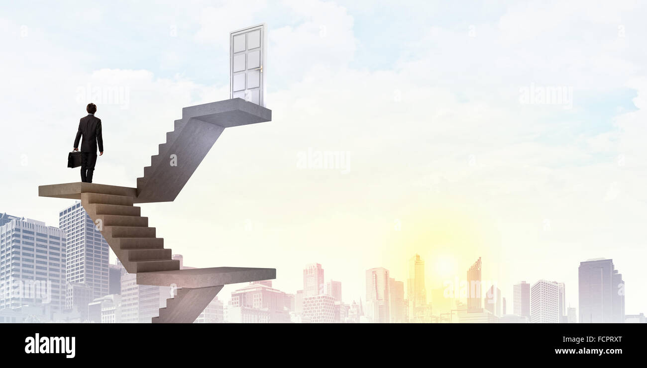 Imprenditore a piedi fino alla scalinata porta in cielo Foto Stock