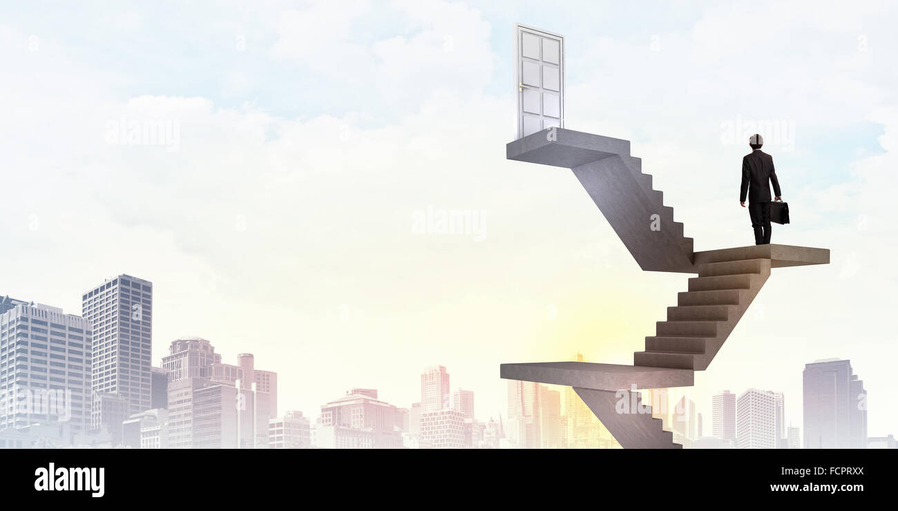 Imprenditore a piedi fino alla scalinata porta in cielo Foto Stock