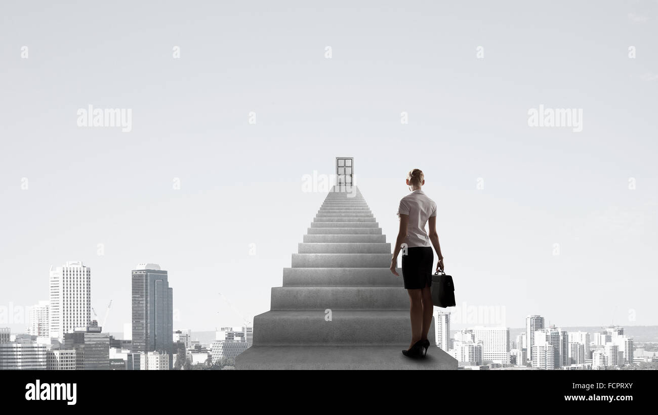 Imprenditrice a piedi fino alla scalinata porta in cielo Foto Stock