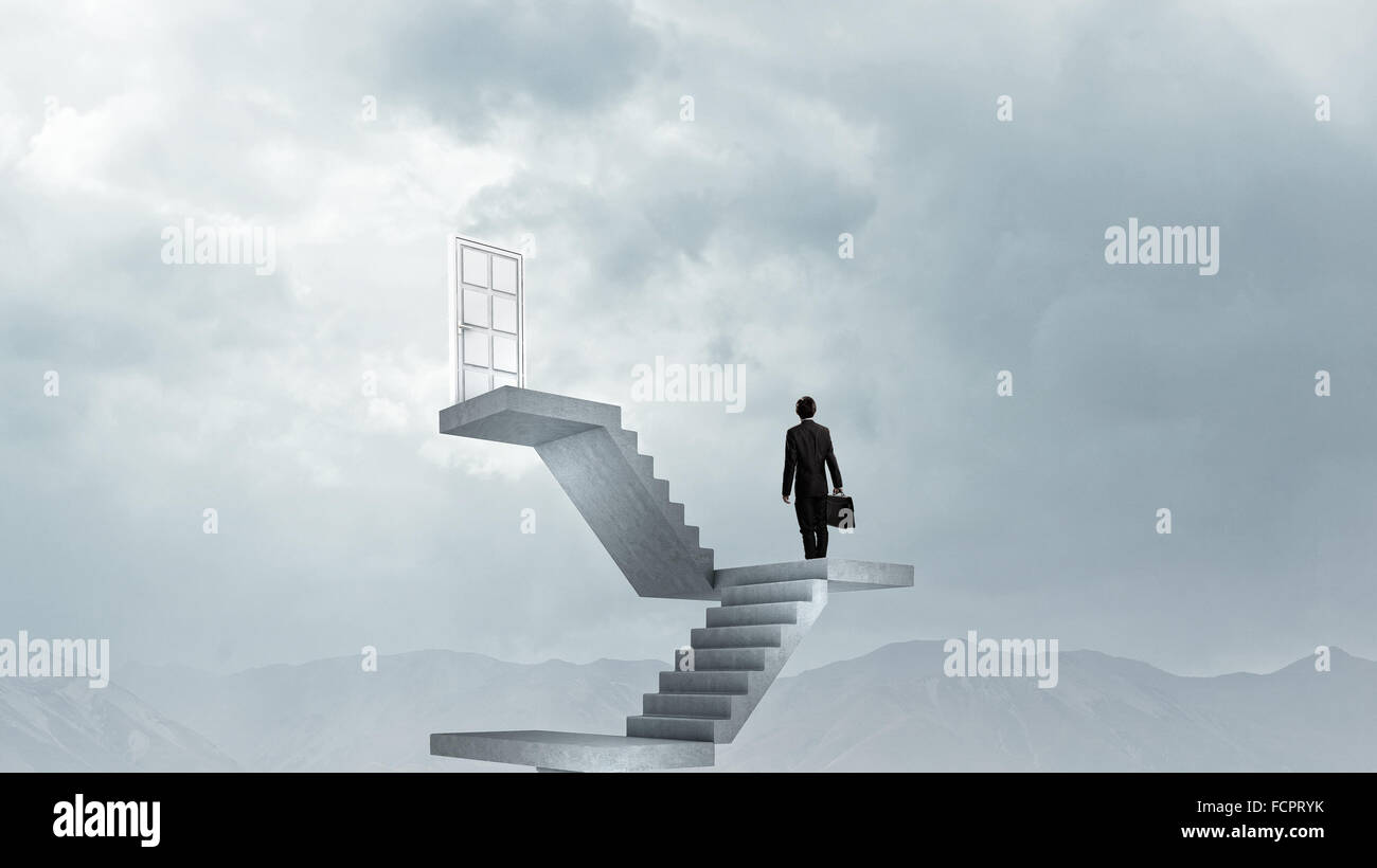 Imprenditore a piedi fino alla scalinata porta in cielo Foto Stock