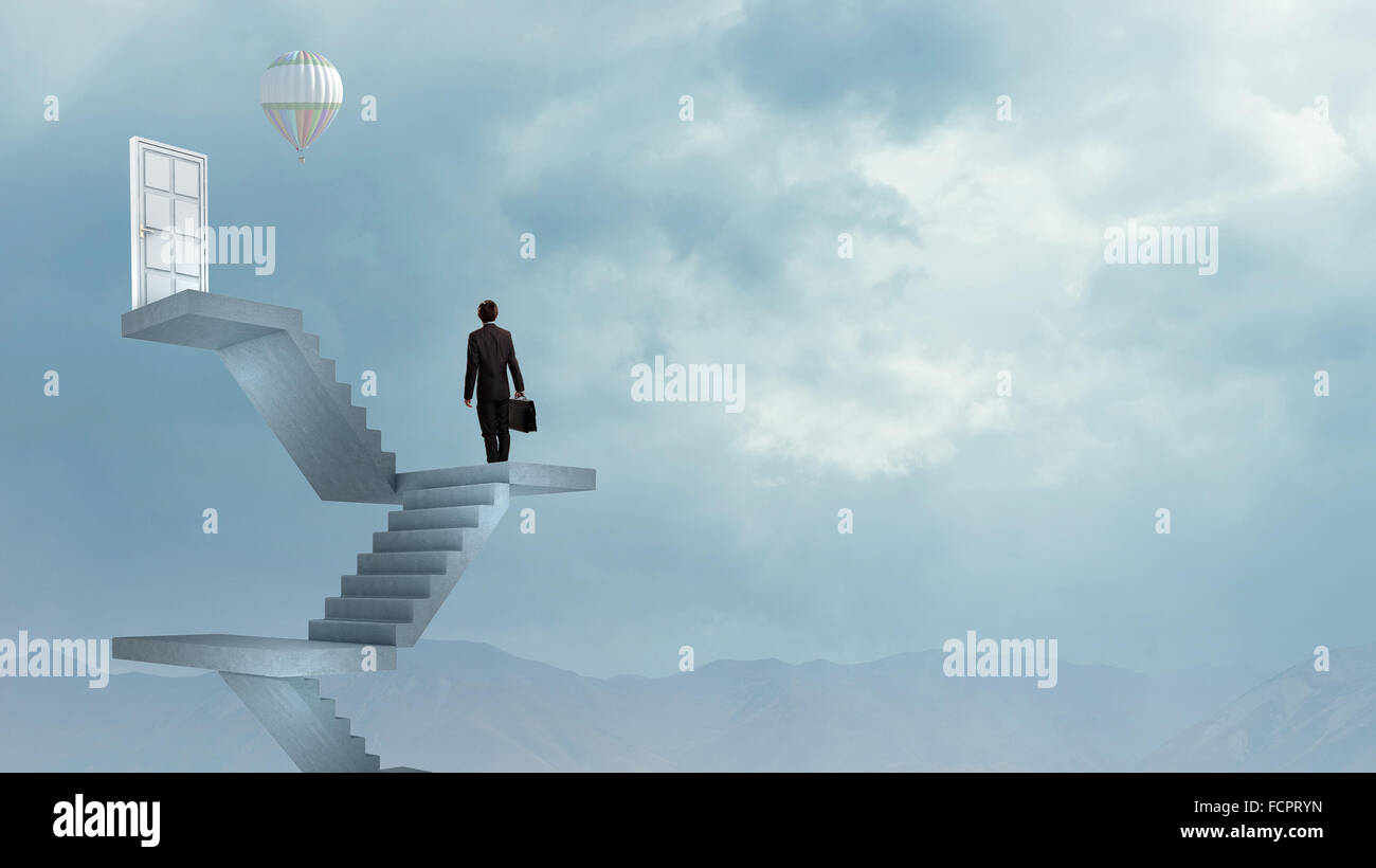 Imprenditore a piedi fino alla scalinata porta in cielo Foto Stock