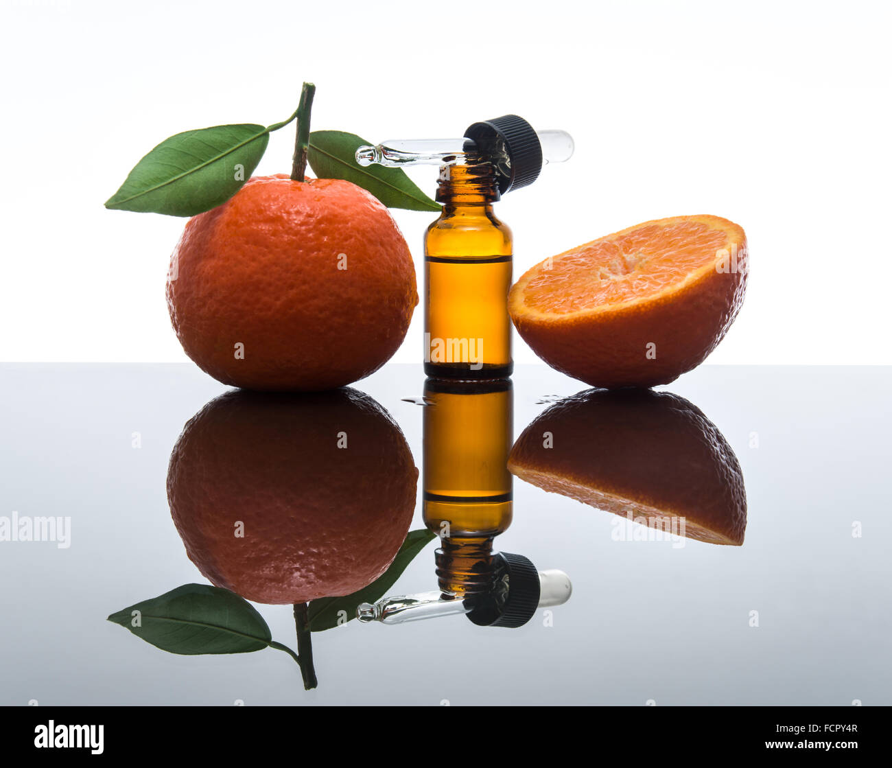 Mandarin / tangerine olio essenziale nel flacone di vetro ambrato con fresco mandarino / mandarino con le foglie e i dropper Foto Stock
