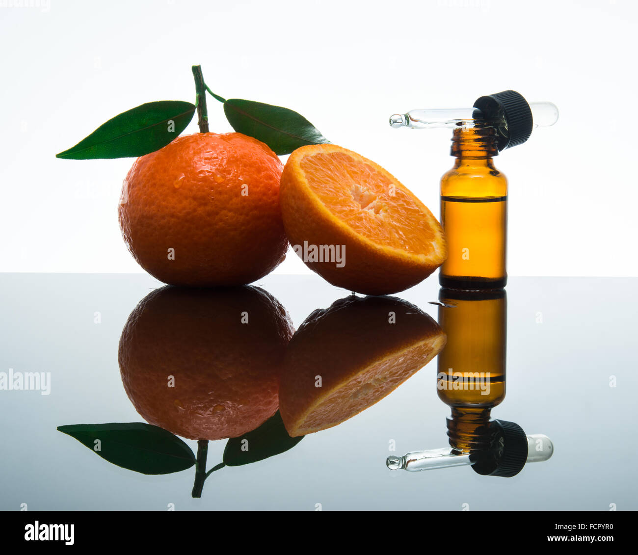 Mandarin / tangerine olio essenziale nel flacone di vetro ambrato con fresco mandarino / mandarino con le foglie e i dropper Foto Stock