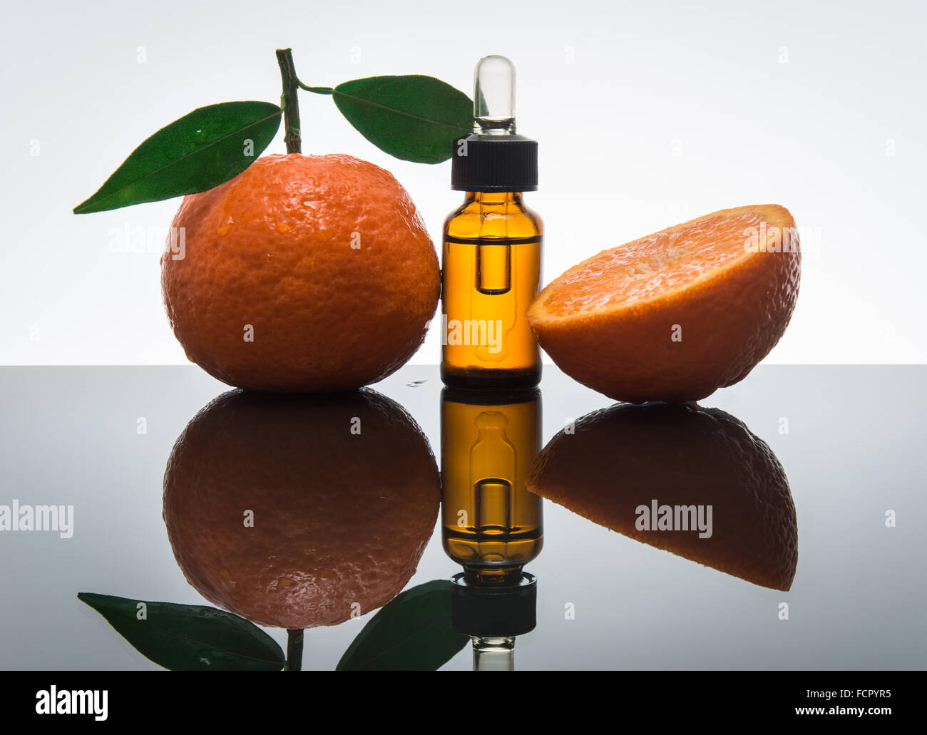 Mandarin / tangerine olio essenziale nel flacone di vetro ambrato con fresco mandarino / mandarino con le foglie e i dropper Foto Stock