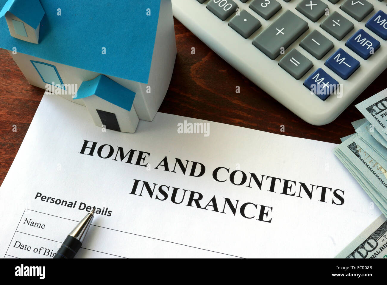 Casa e assicurazione del contenuto e forma di dollari sul tavolo. Foto Stock