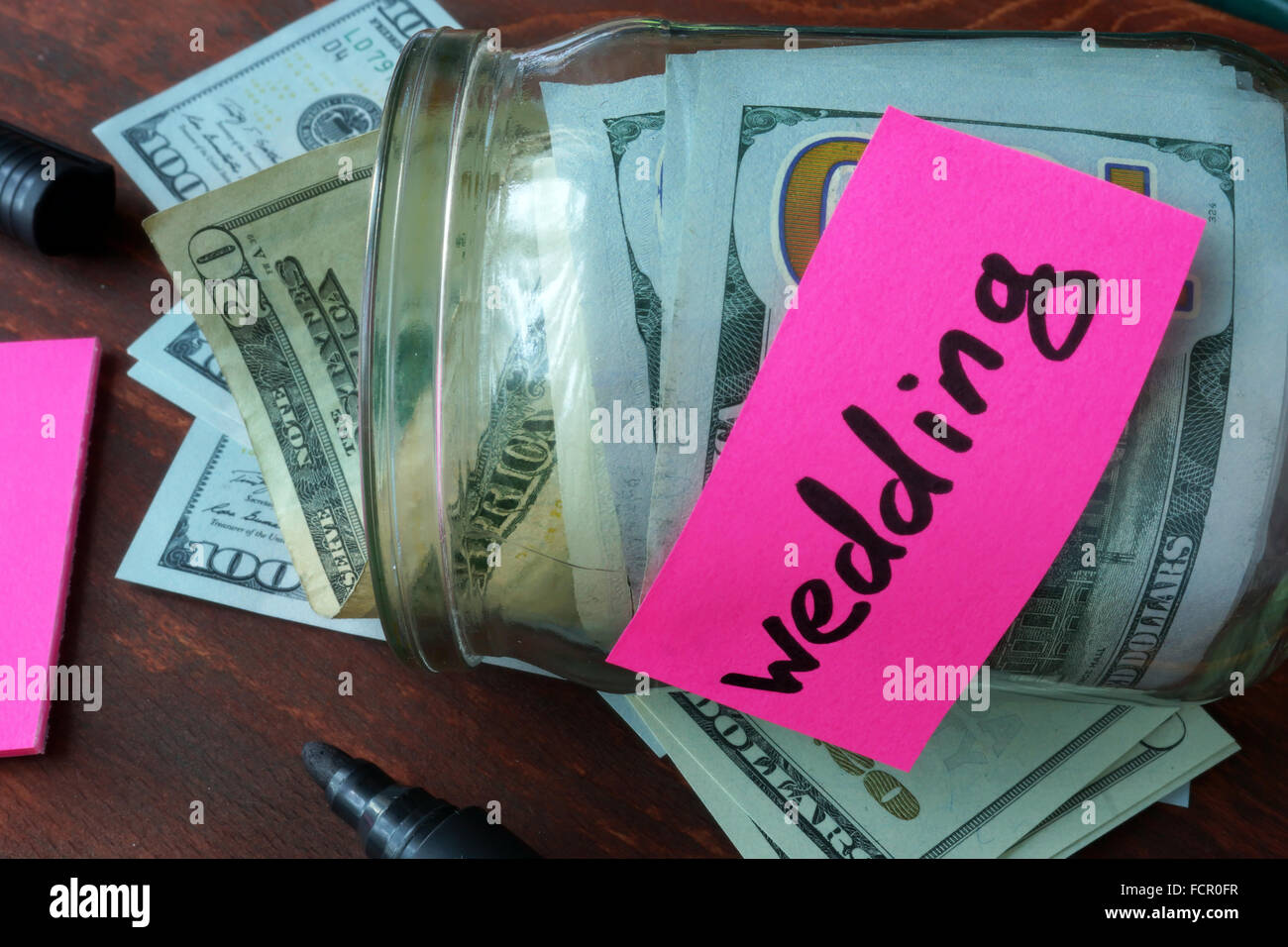 Vaso con etichetta di nozze e il denaro sul tavolo. Risparmio di denaro concetto. Foto Stock