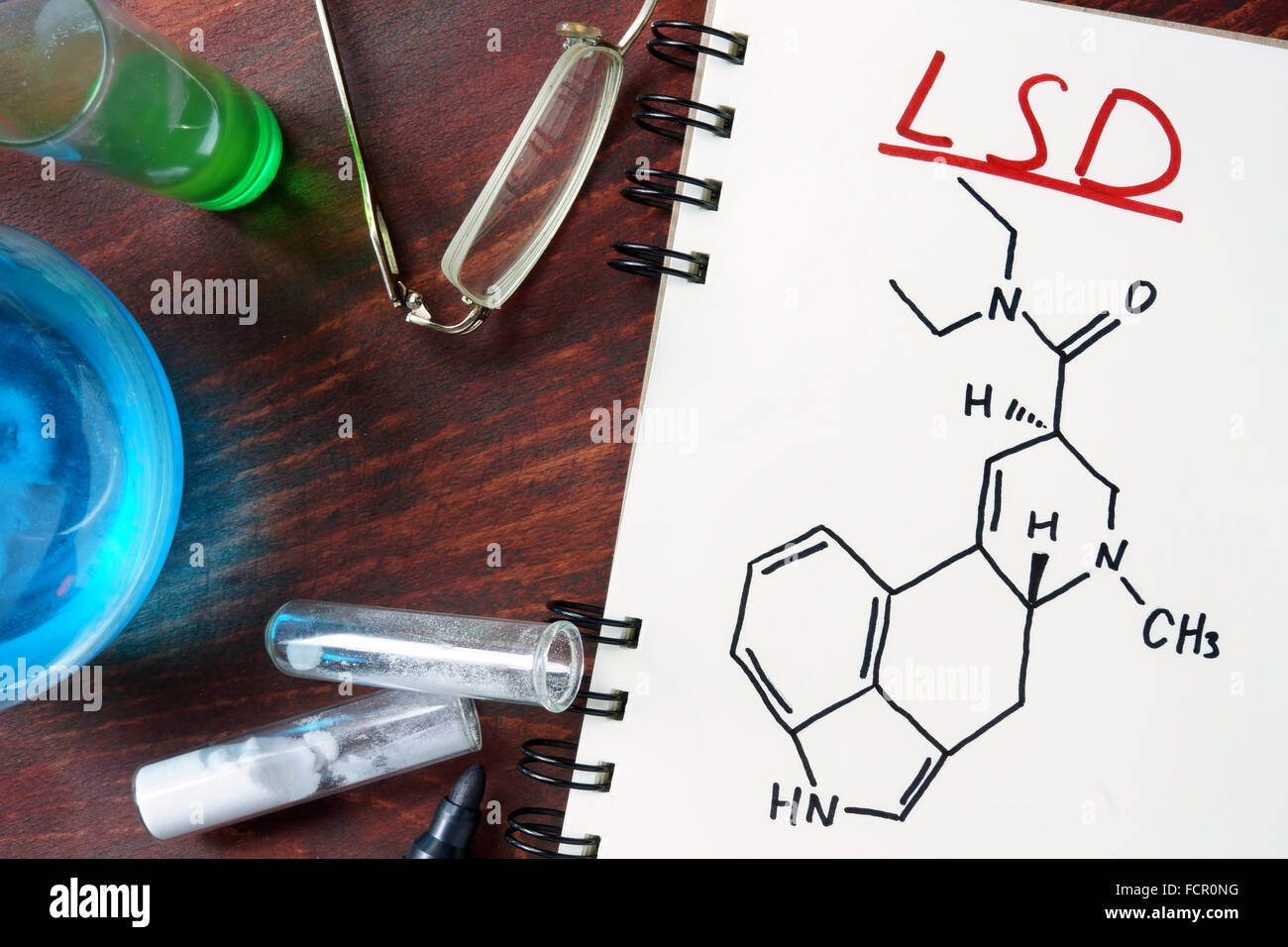 Blocco note con formula chimica di LSD sul tavolo di legno. Il concetto di droga. Foto Stock