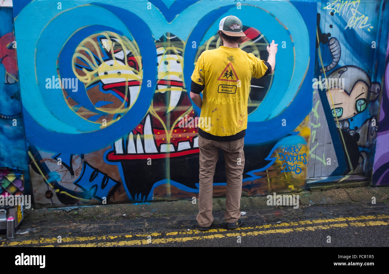 Brighton Regno Unito 24 Gennaio 2016 - artisti di graffiti sul lavoro lungo Trafalgar Lane nel North Laine area di Brighton che è diventato una popolare area di disegno per le loro opere d'arte Credito: Simon Dack/Alamy Live News Foto Stock