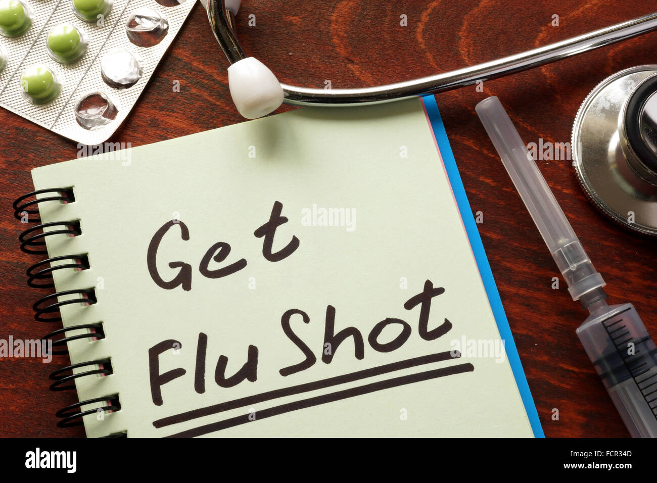Notebook con le parole Get Flu shot sul tavolo. Foto Stock